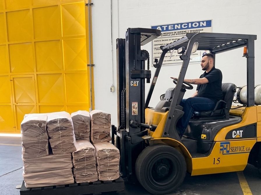 Montacargas cargando pedido de bolsas kraft Los Juanes Plus para despacho